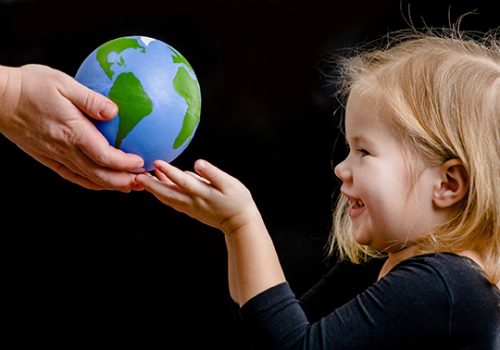 Mother gives the planet into the hands of a child. Isolated on d